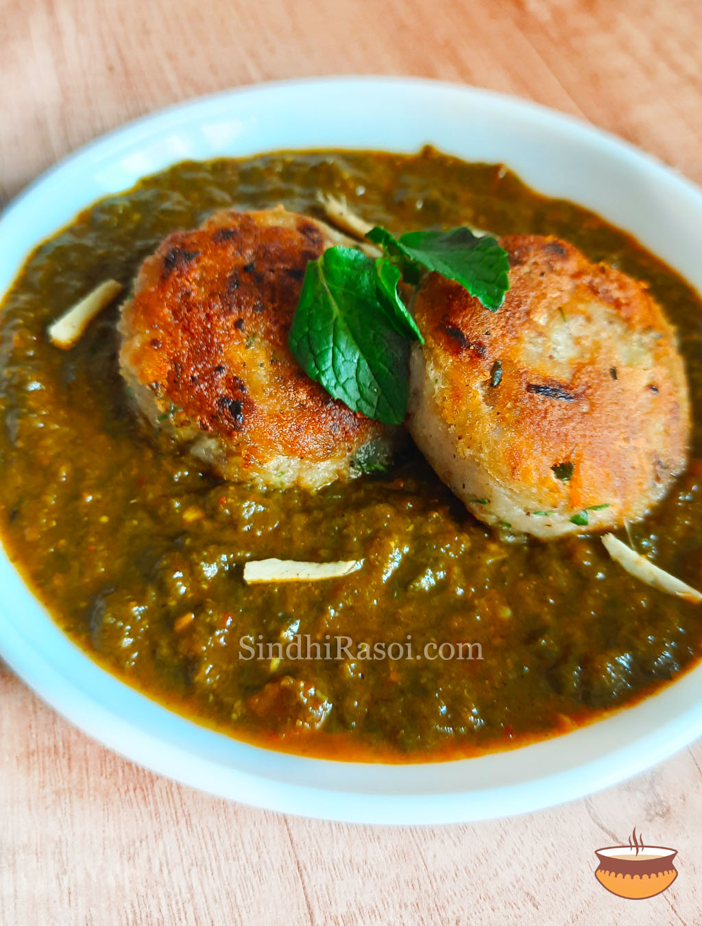 sindhi lotuss tem tikki in Spinach curry